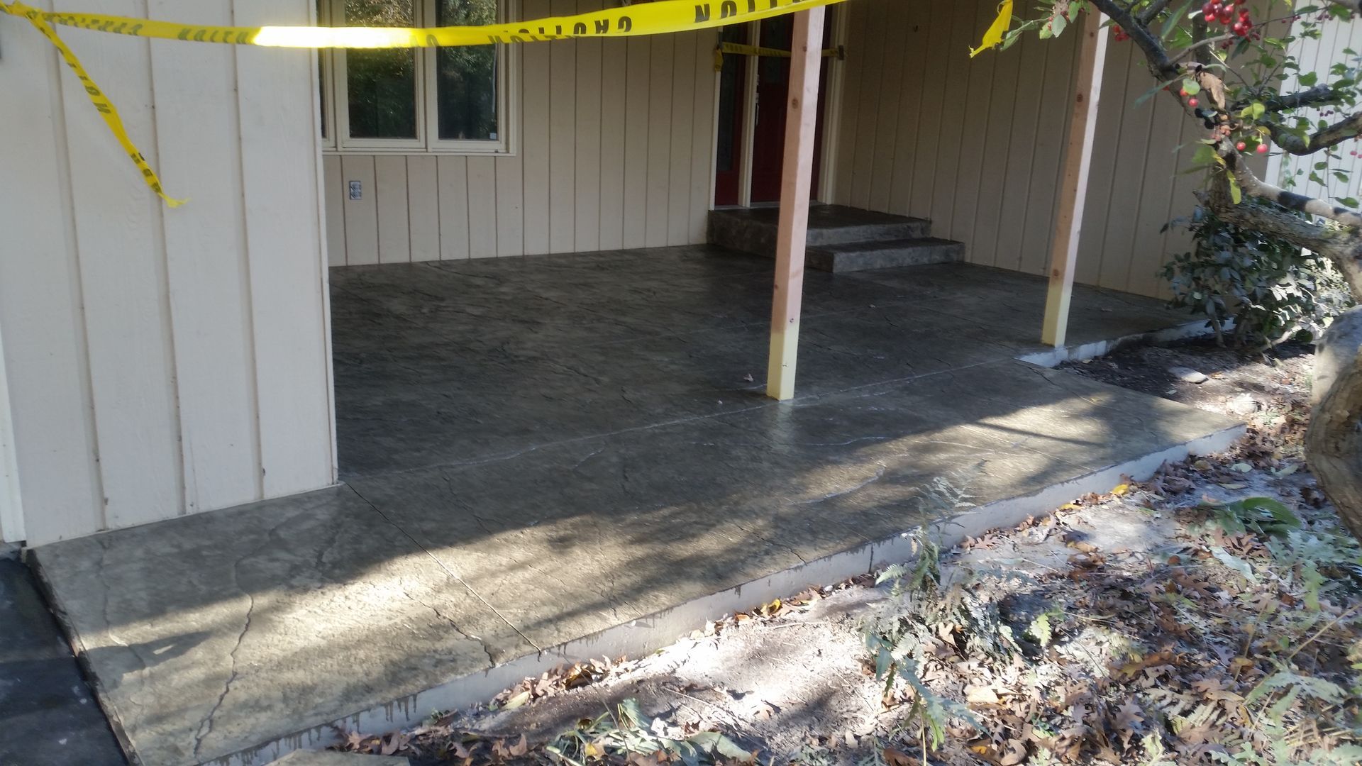A concrete porch is being built in front of a house.