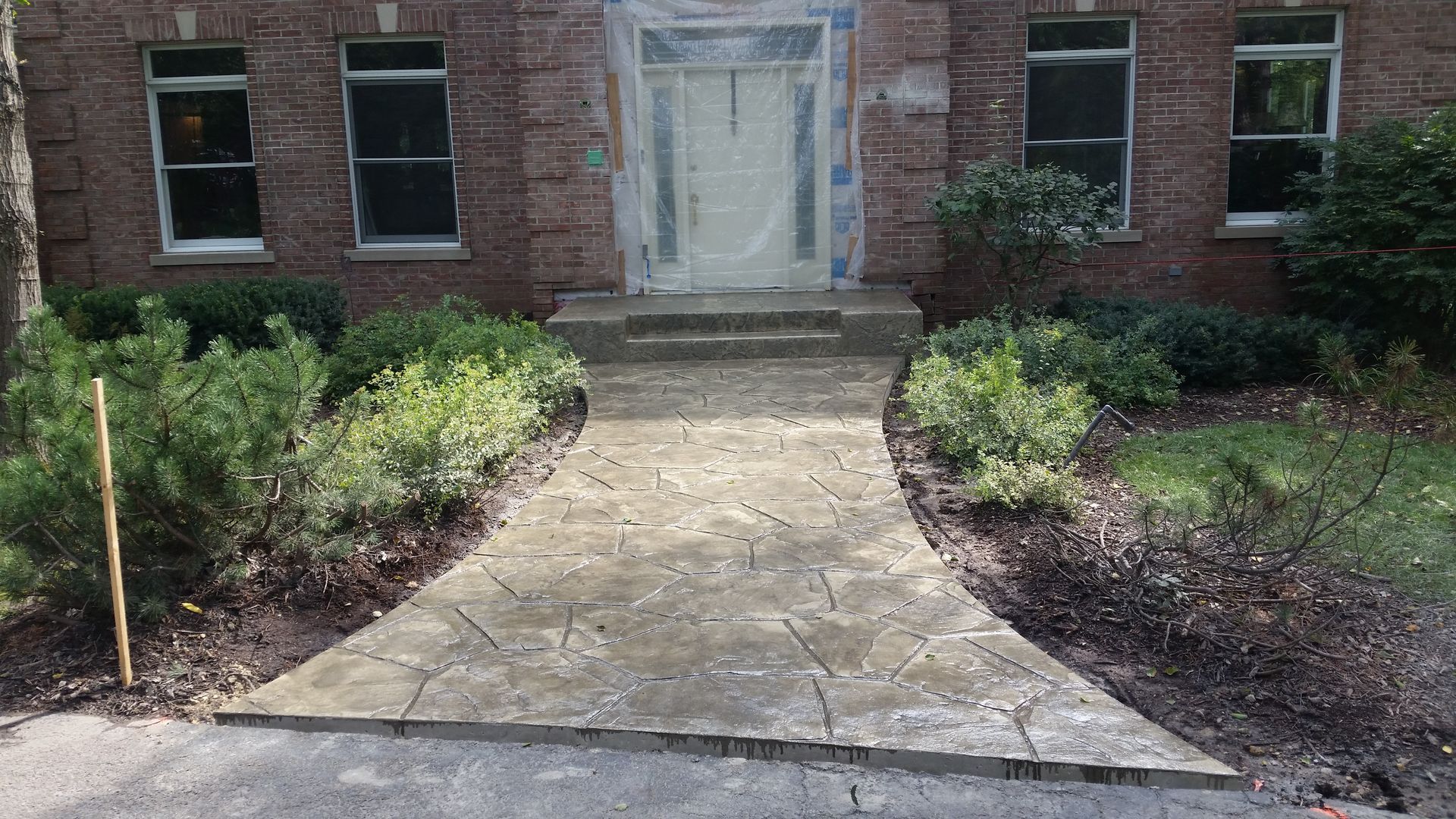 A brick house with a stone walkway leading to the front door.
