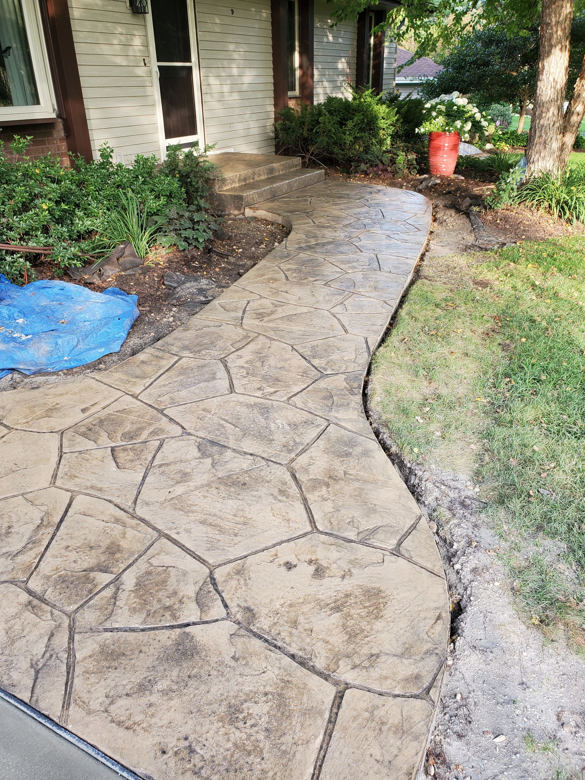 A concrete walkway is being built in front of a house.