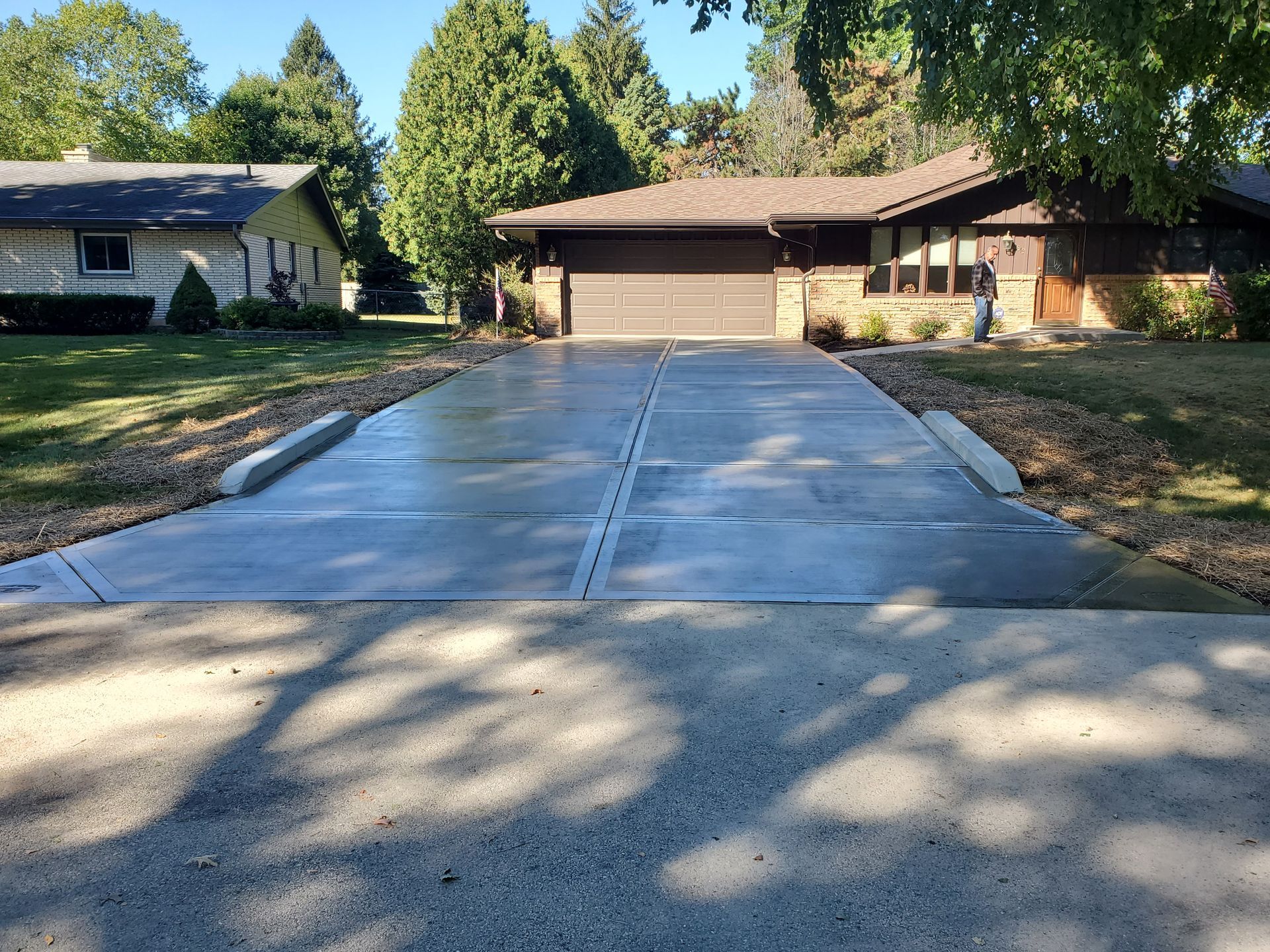 A concrete driveway leading to a house with a garage.