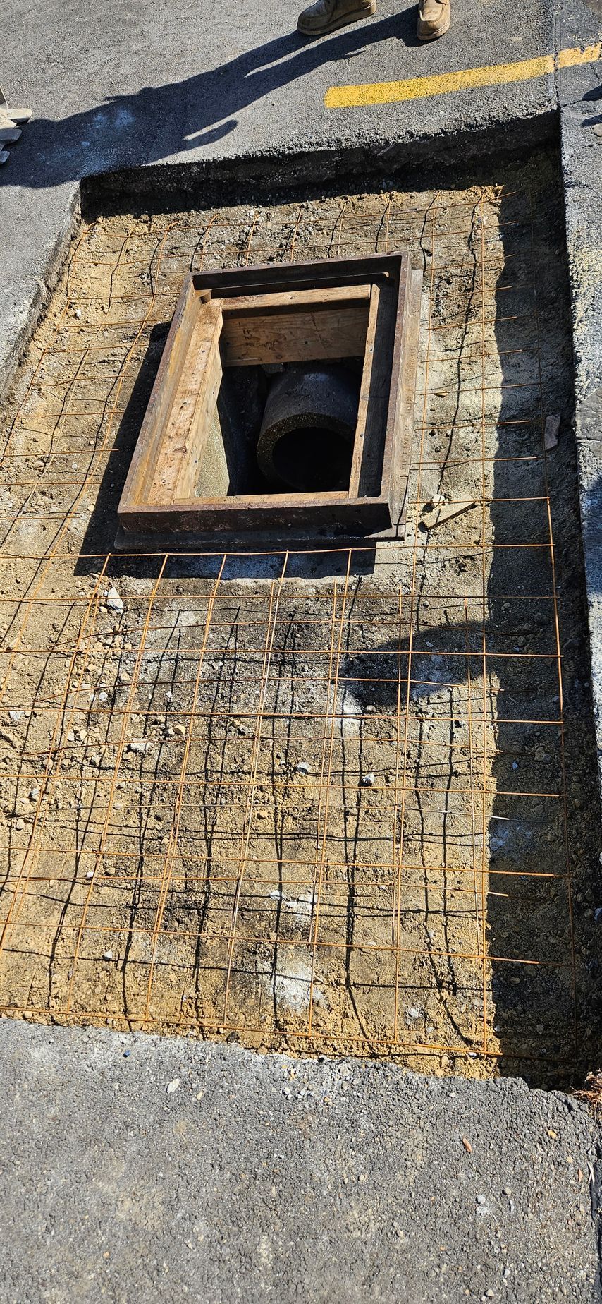 A manhole cover is being built on the side of the road.