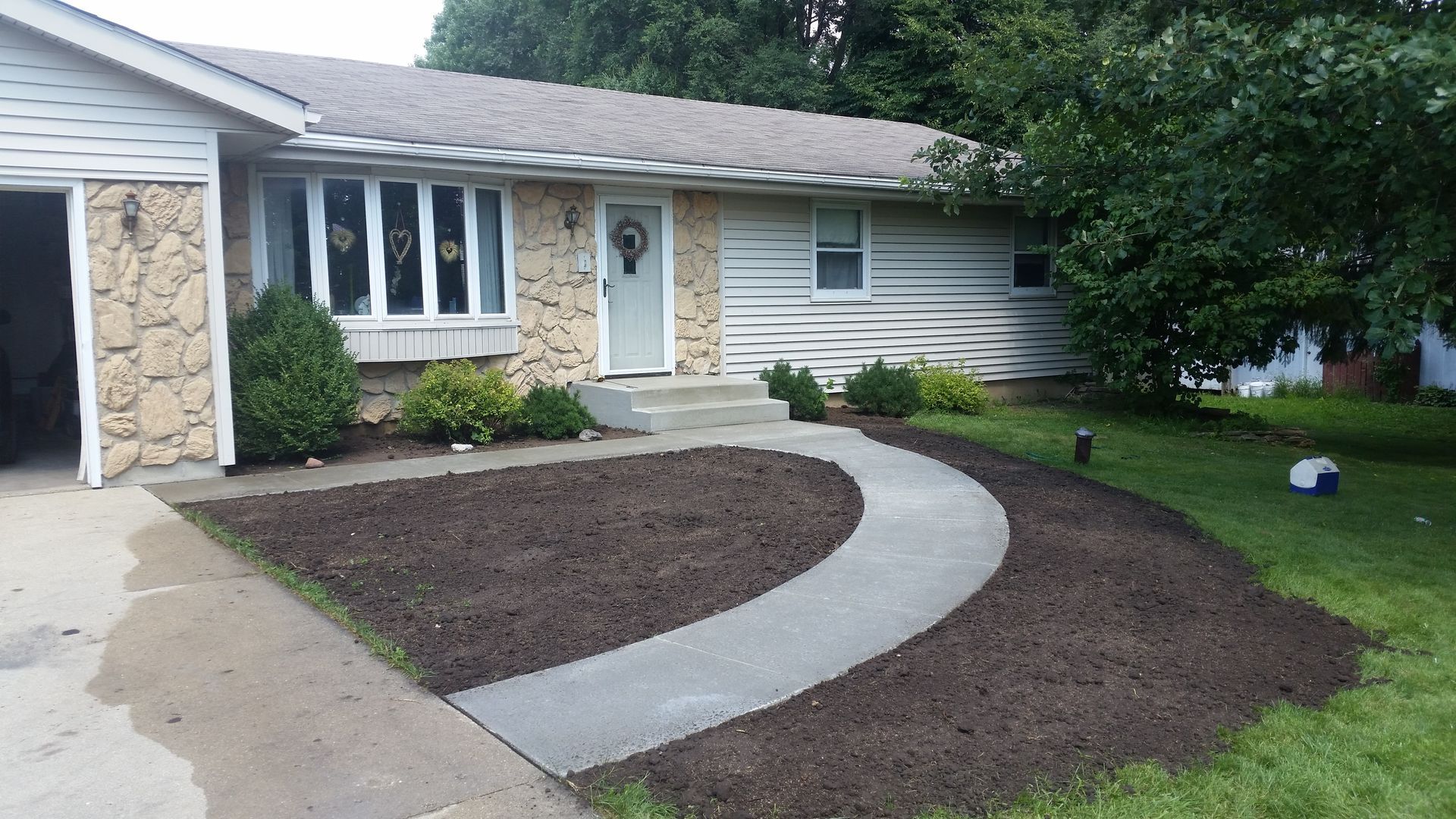 A house with a concrete walkway leading to the front door