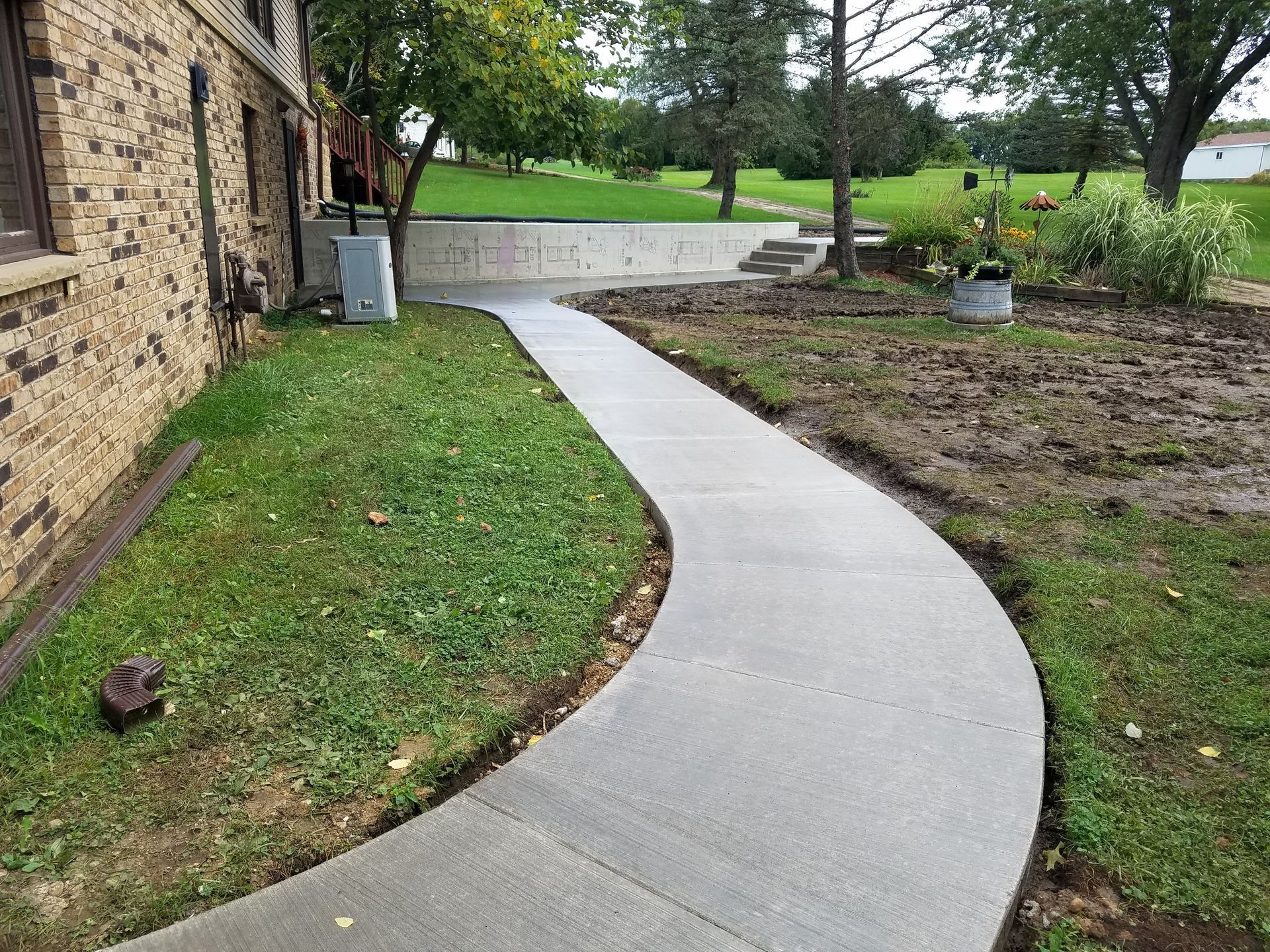 A concrete walkway is being built in front of a brick building.