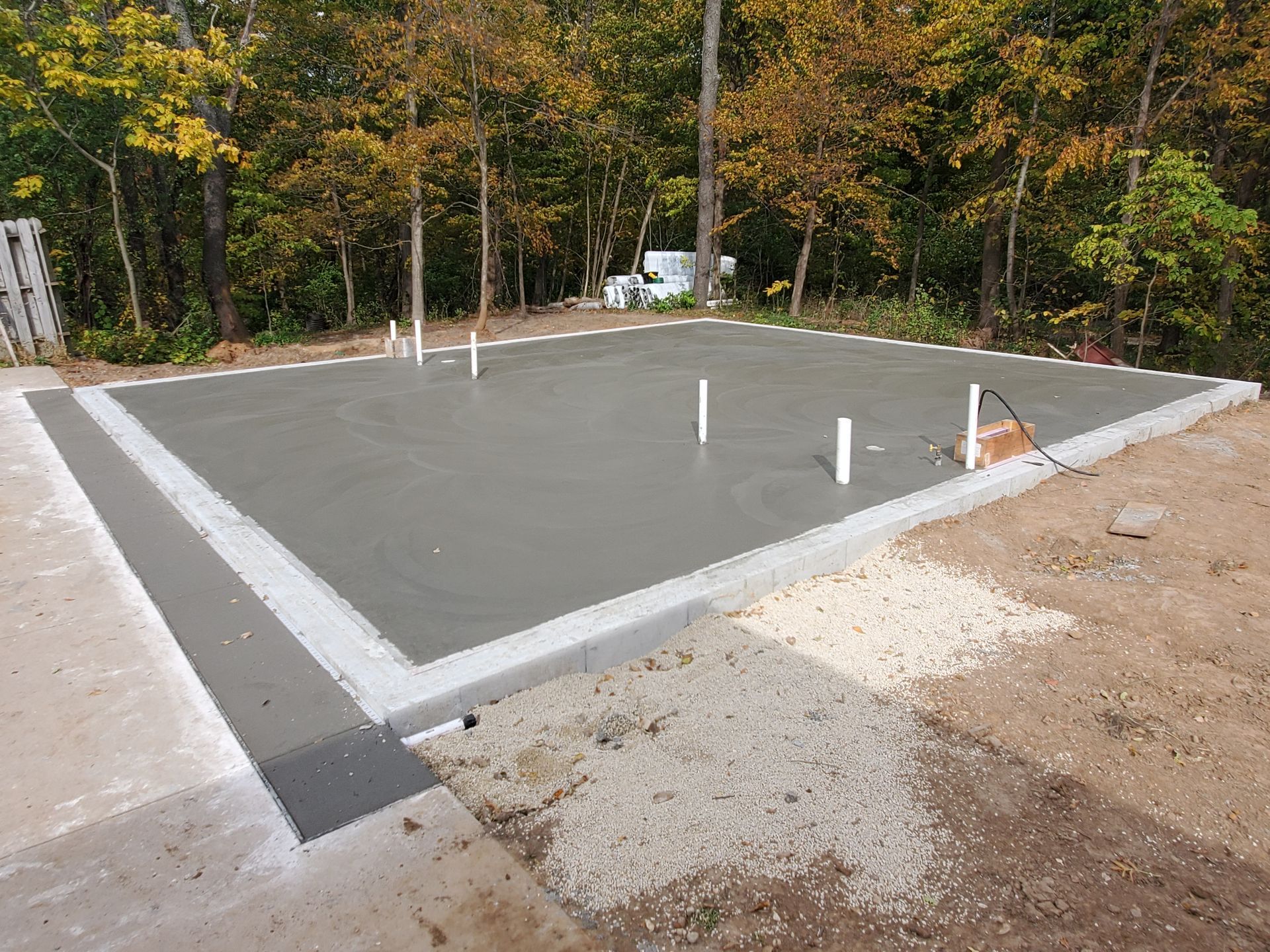 A concrete foundation is being built in the middle of a forest.