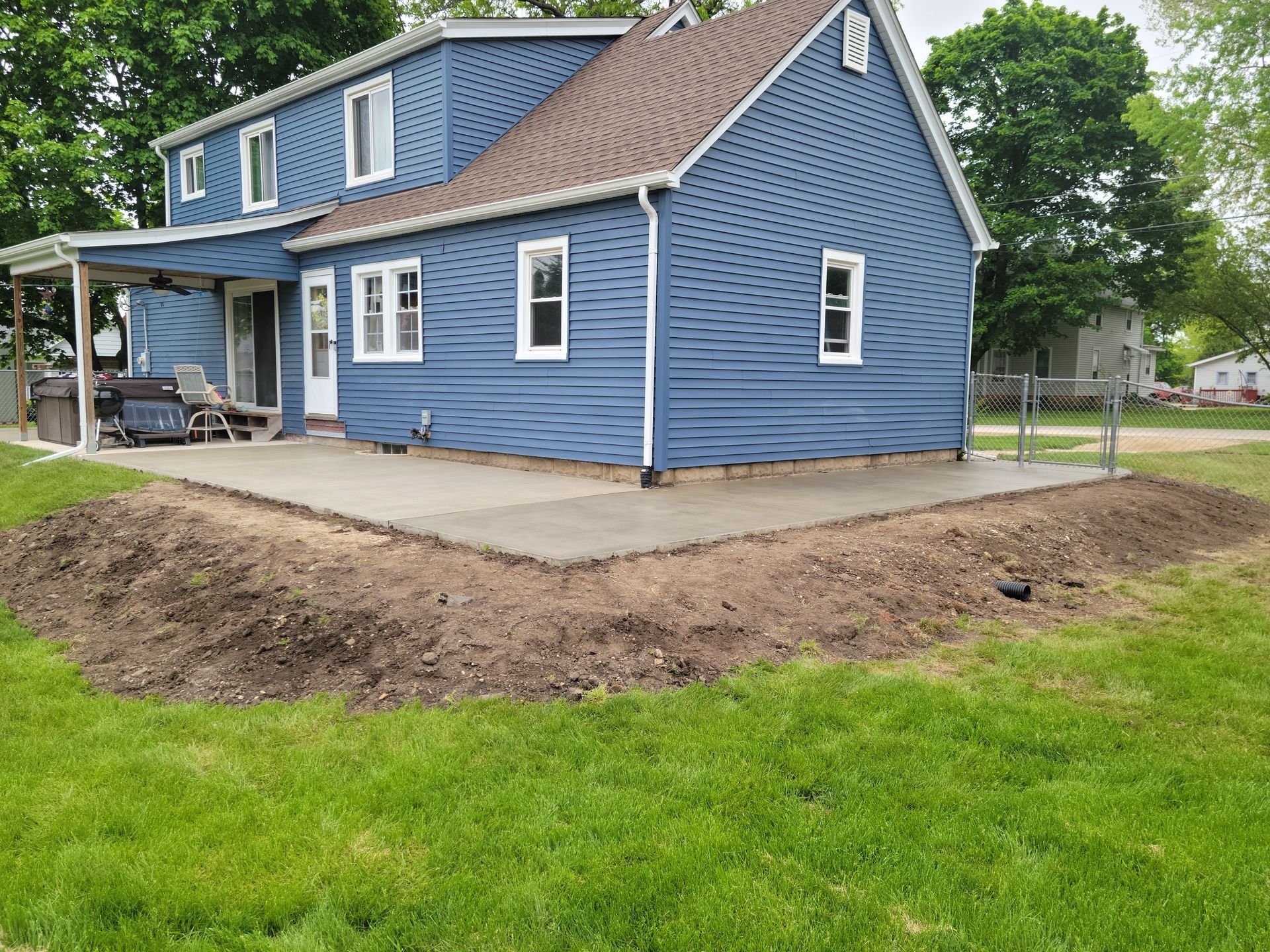 A blue house with a concrete patio in front of it.
