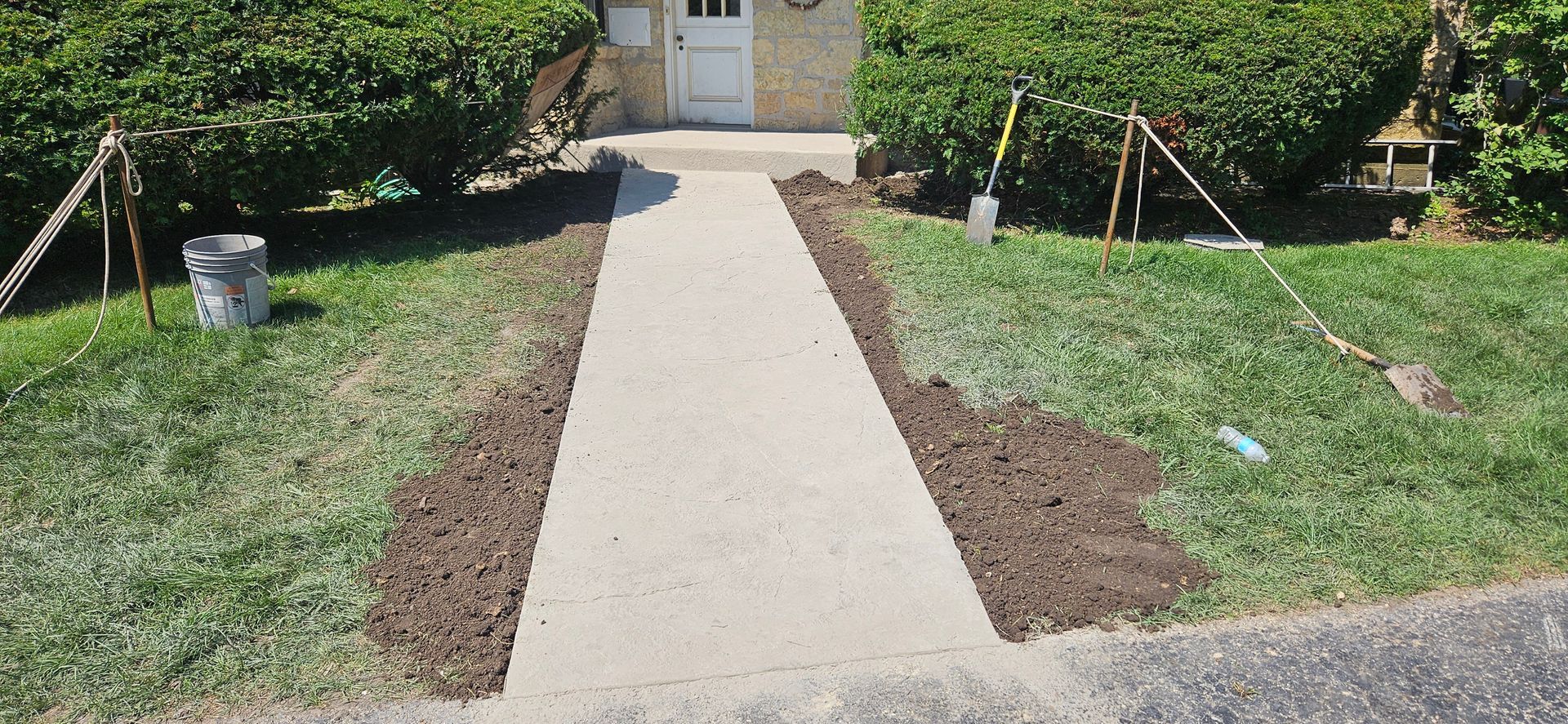 A concrete walkway is being built in front of a house.