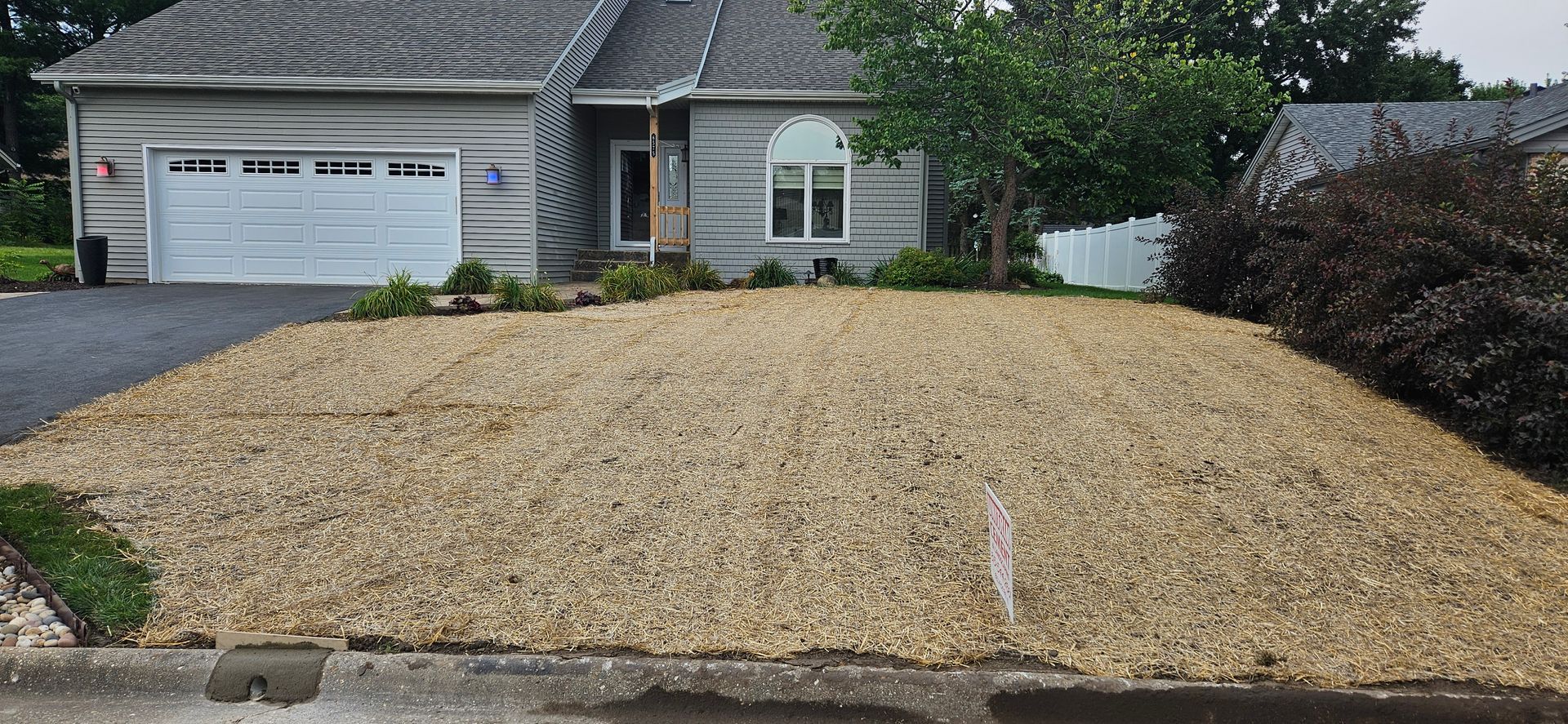 A house with a large pile of gravel in front of it.