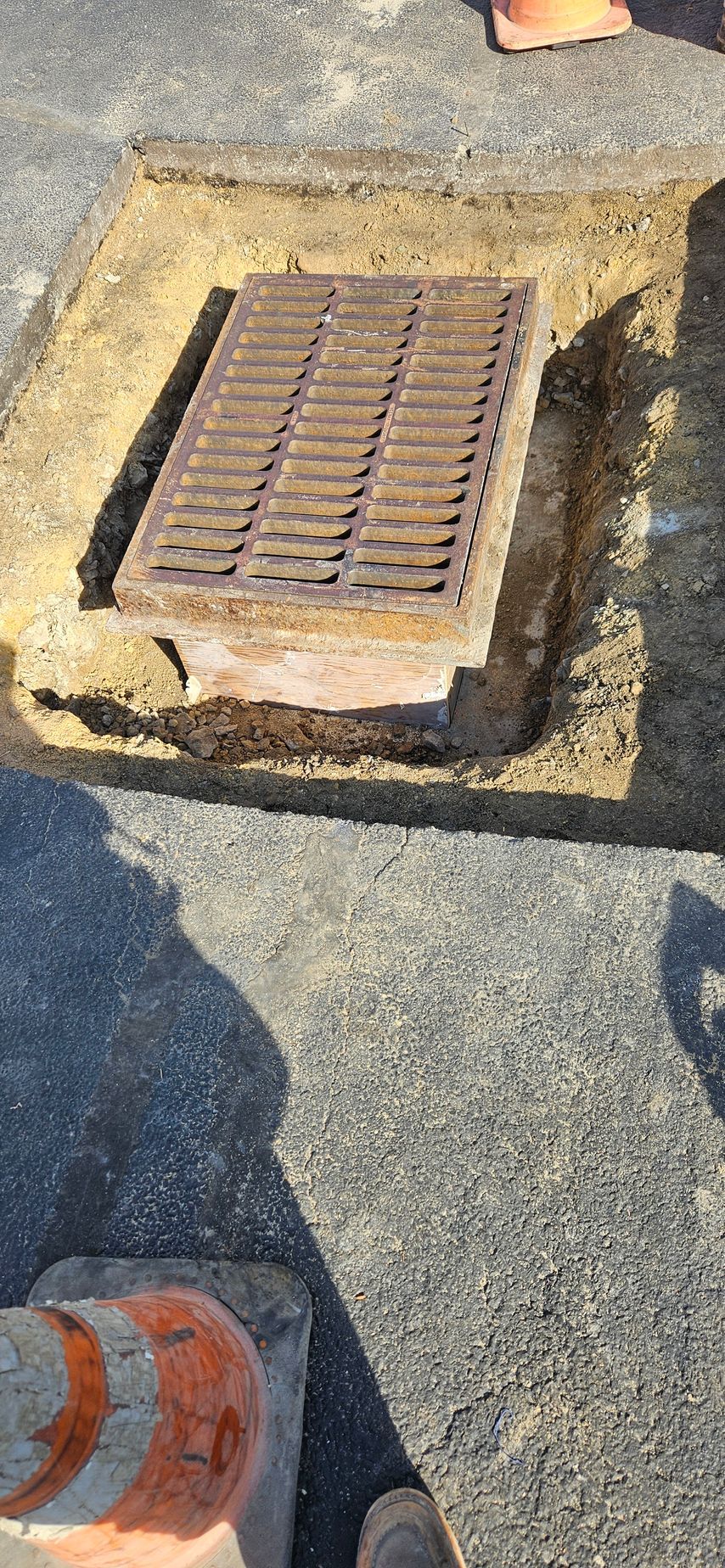 A manhole cover is sitting in the middle of a hole in the ground.