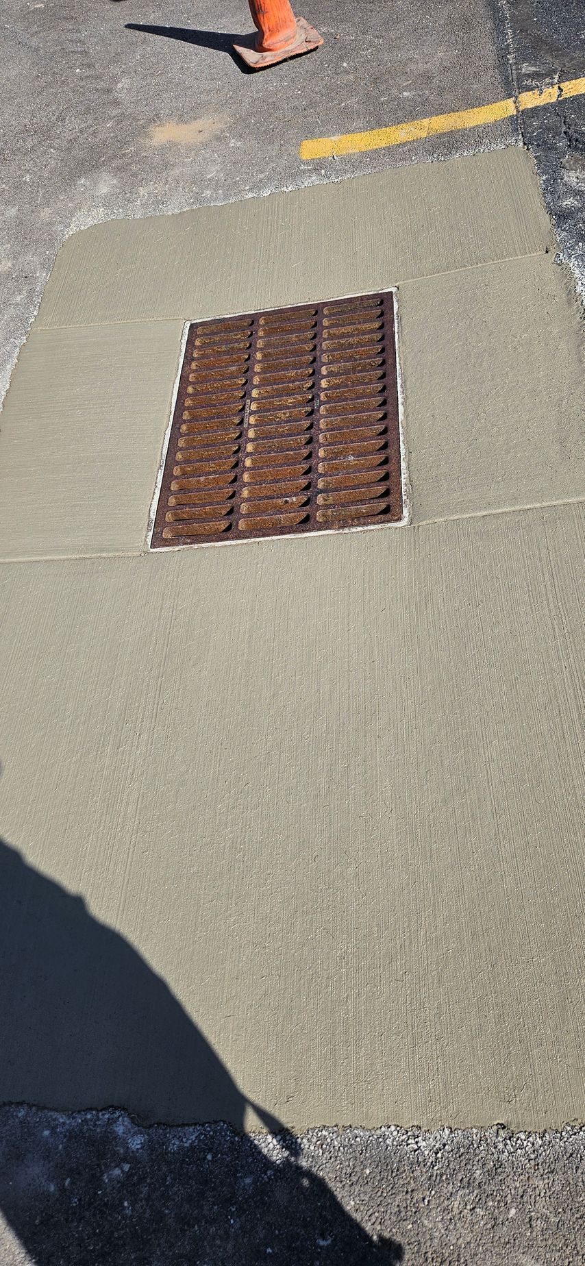 A manhole cover is sitting on top of a concrete surface.