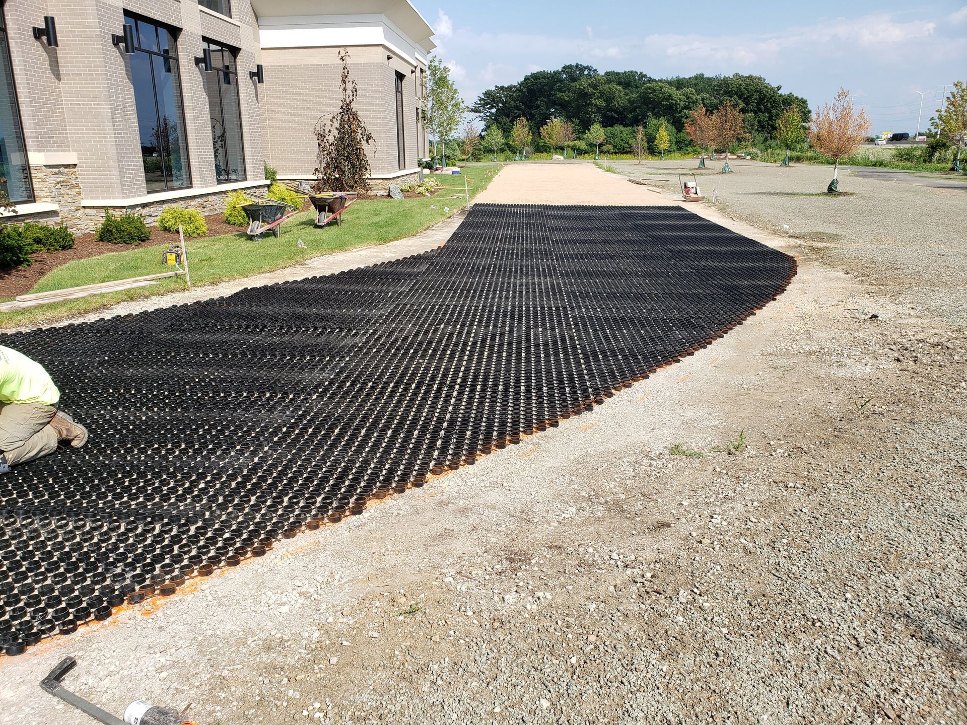 A gravel driveway is being built in front of a house.