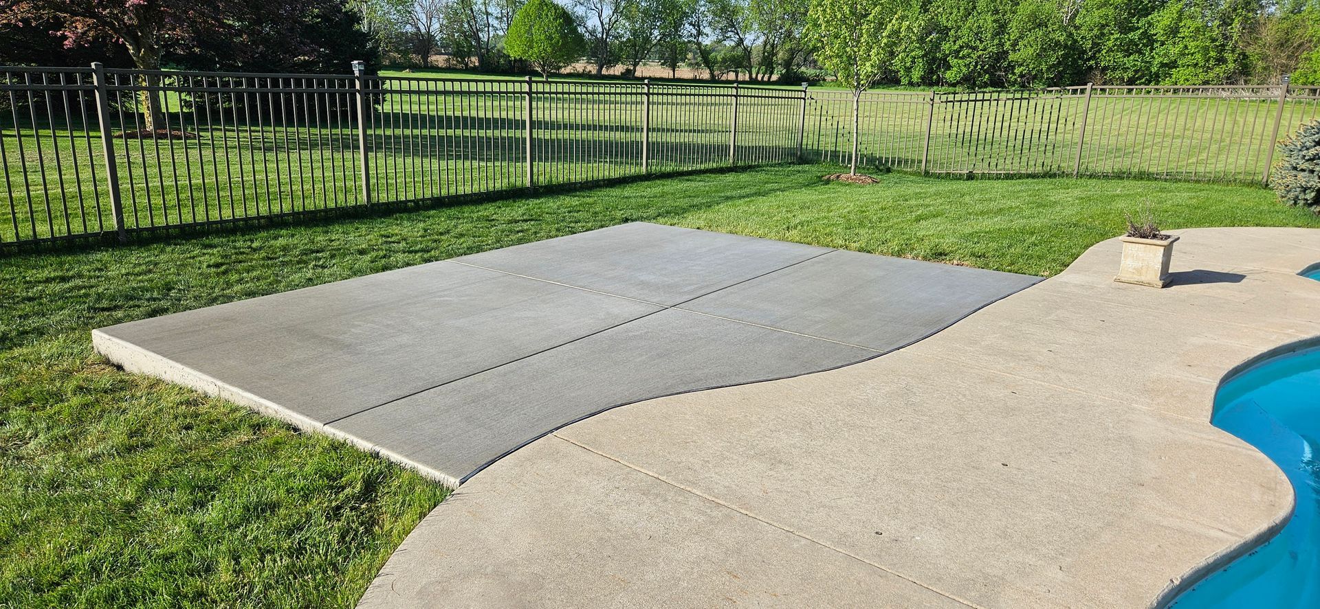 A large concrete slab is sitting next to a swimming pool.
