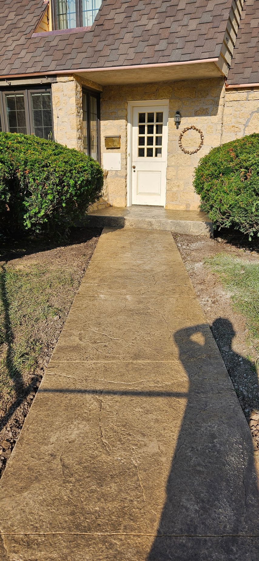 A concrete walkway leading to the front door of a house.
