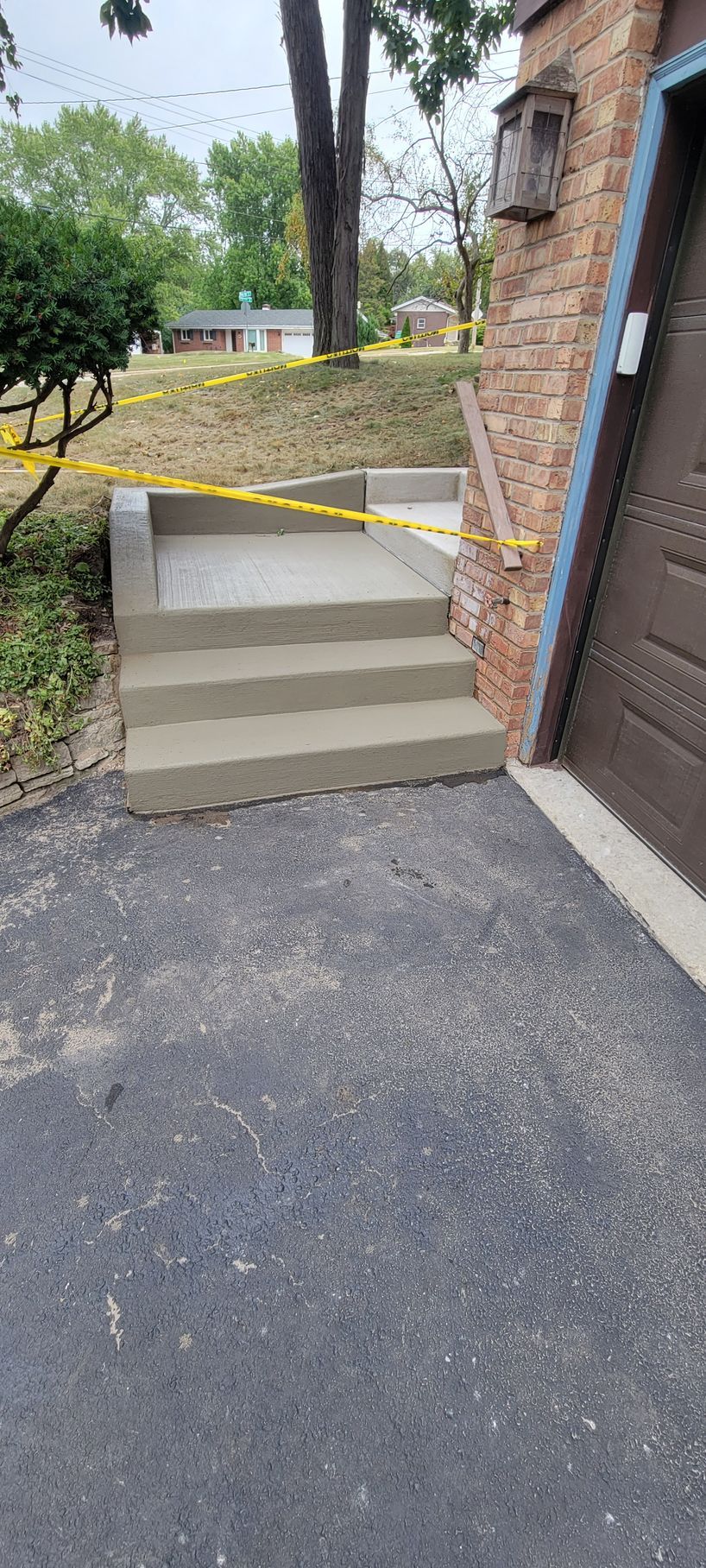 A set of concrete steps leading up to a garage next to a brick building.