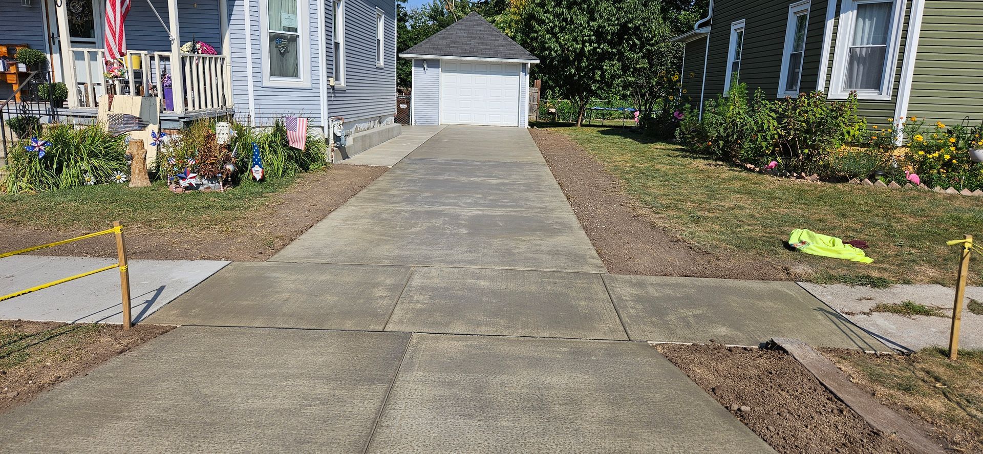 A concrete driveway leading to a house with a garage.