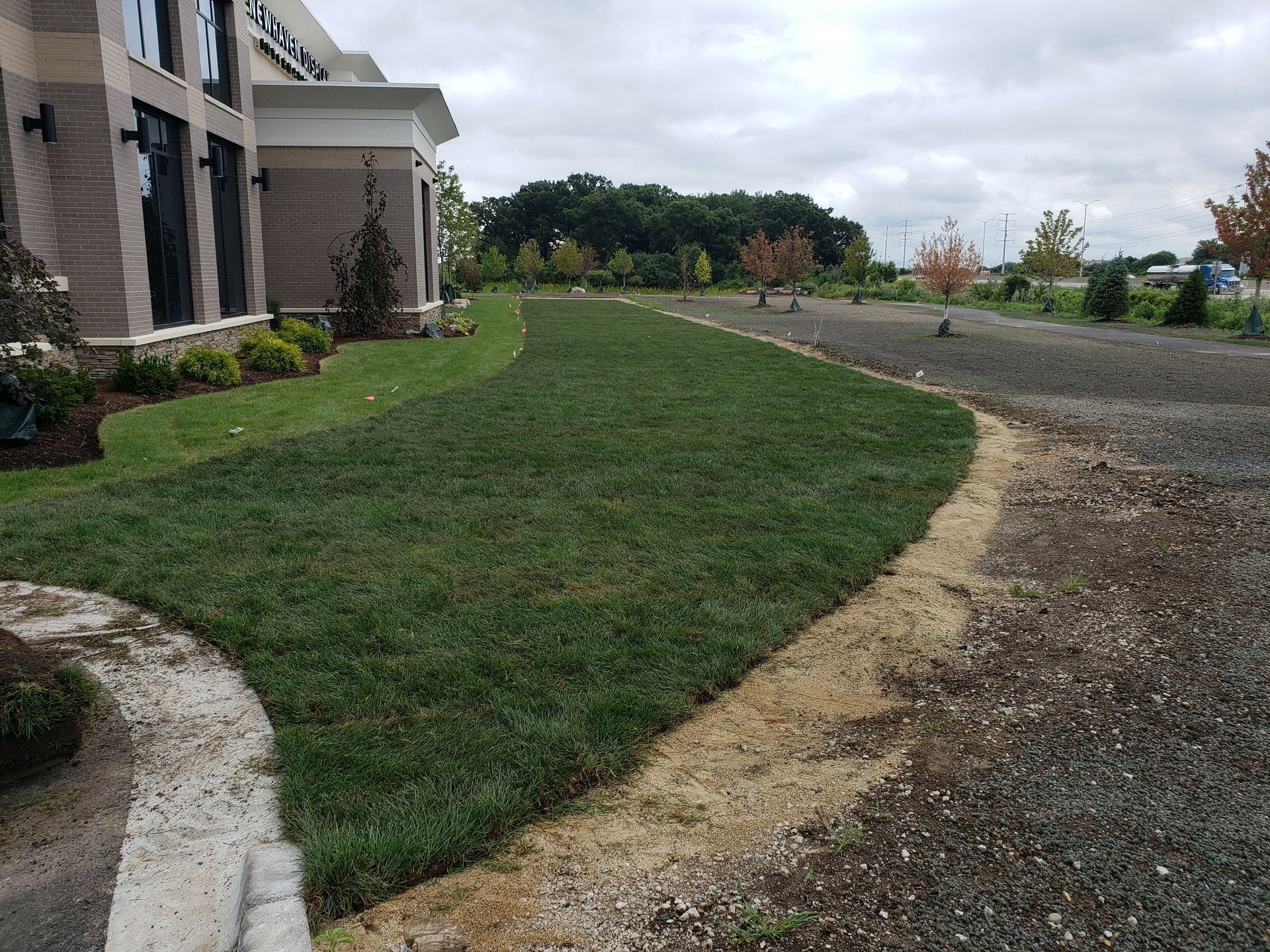 A large building with a lush green lawn in front of it.