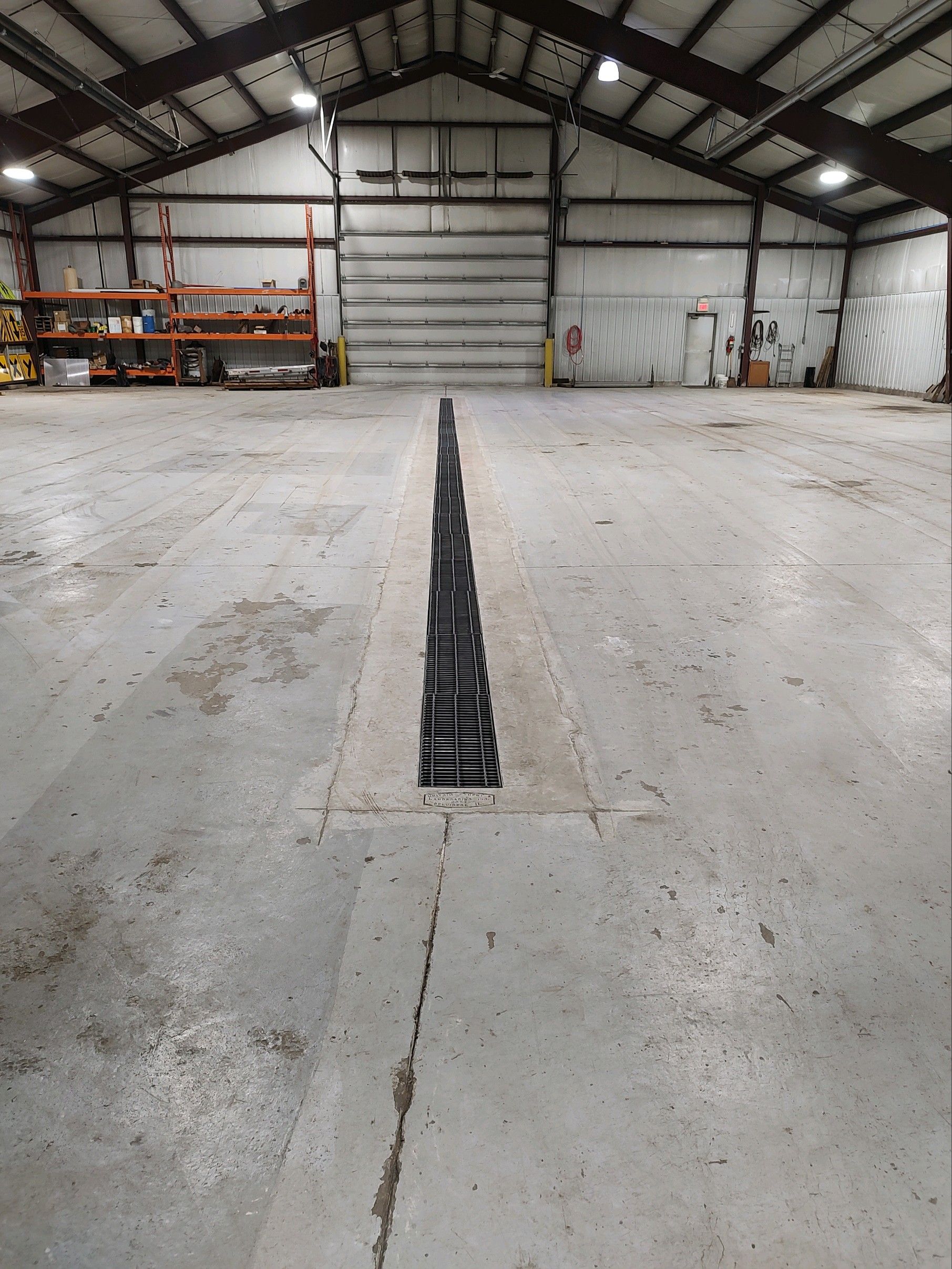 A large warehouse with a drain in the middle of it