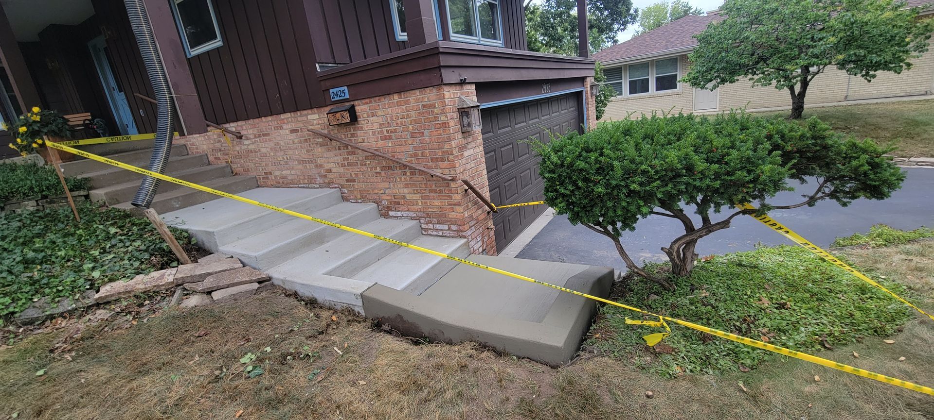 A concrete walkway is being built in front of a house.