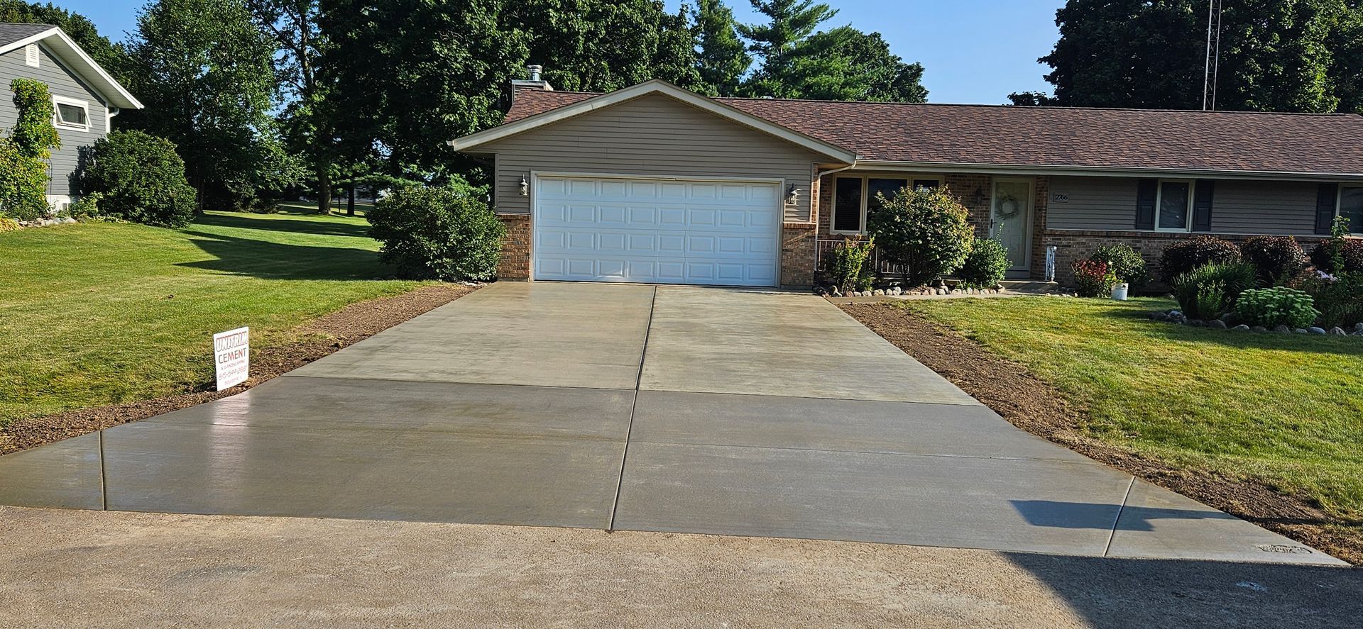 A driveway leading to a house with a white garage door