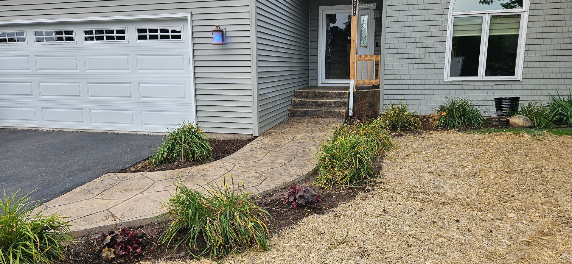 A house with a walkway leading to the front door and a garage.