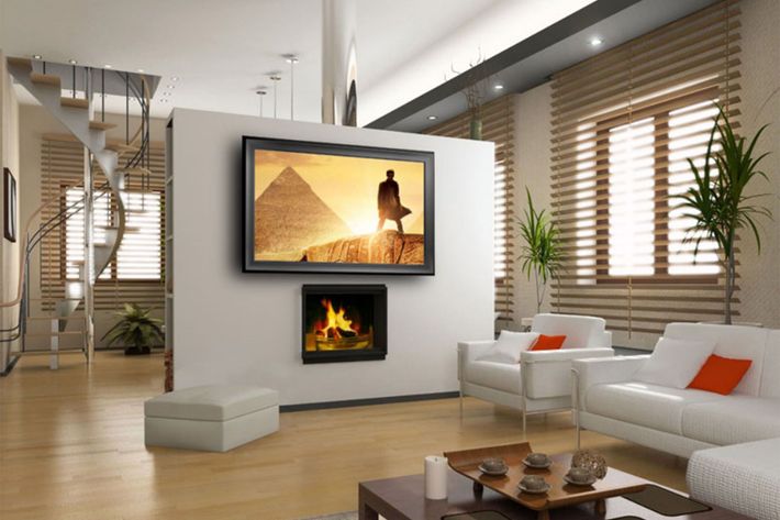 A living room with a couch and a television on the wall
