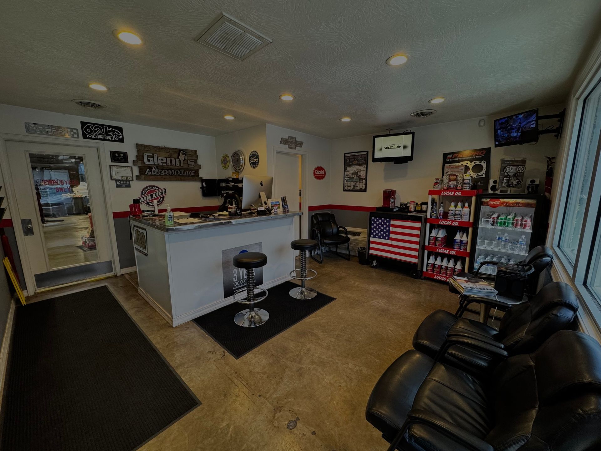 Small office lobby with front counter, stools, black chairs, and American flag decor.