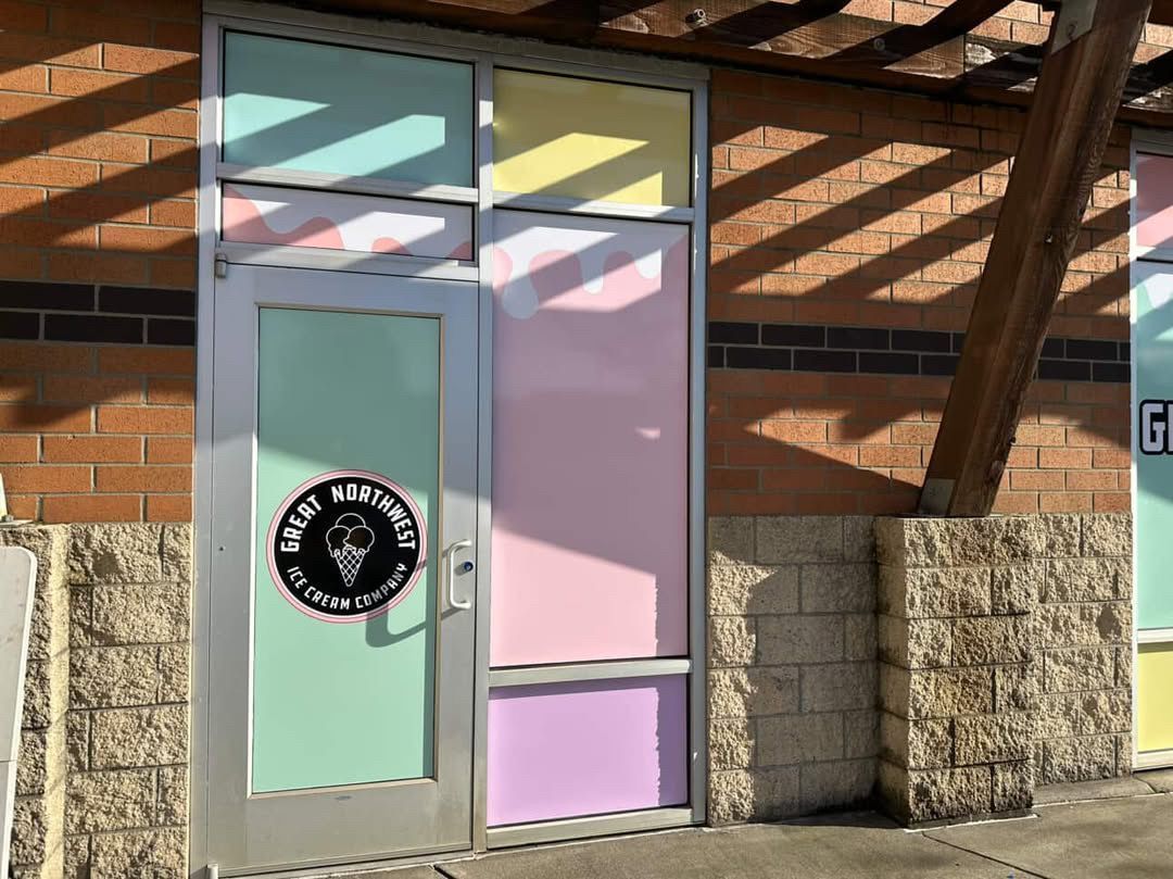 A storefront with a colorful window, door, and logo for an ice cream shop.