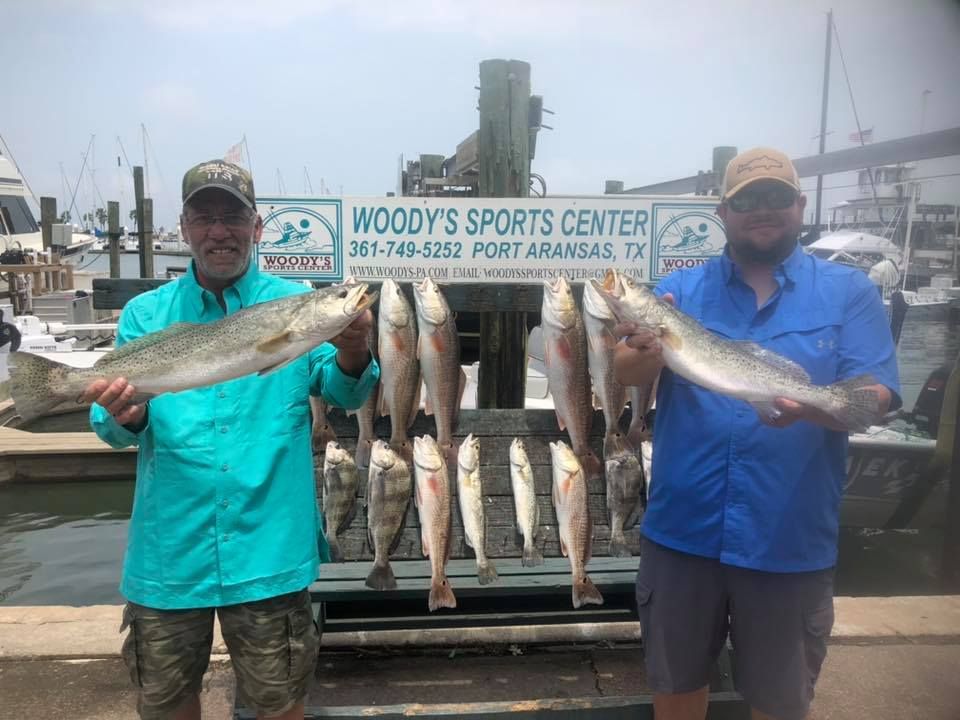 Two men posing with a catch of fish at Woody's Sports Center in Port Aransas, TX.