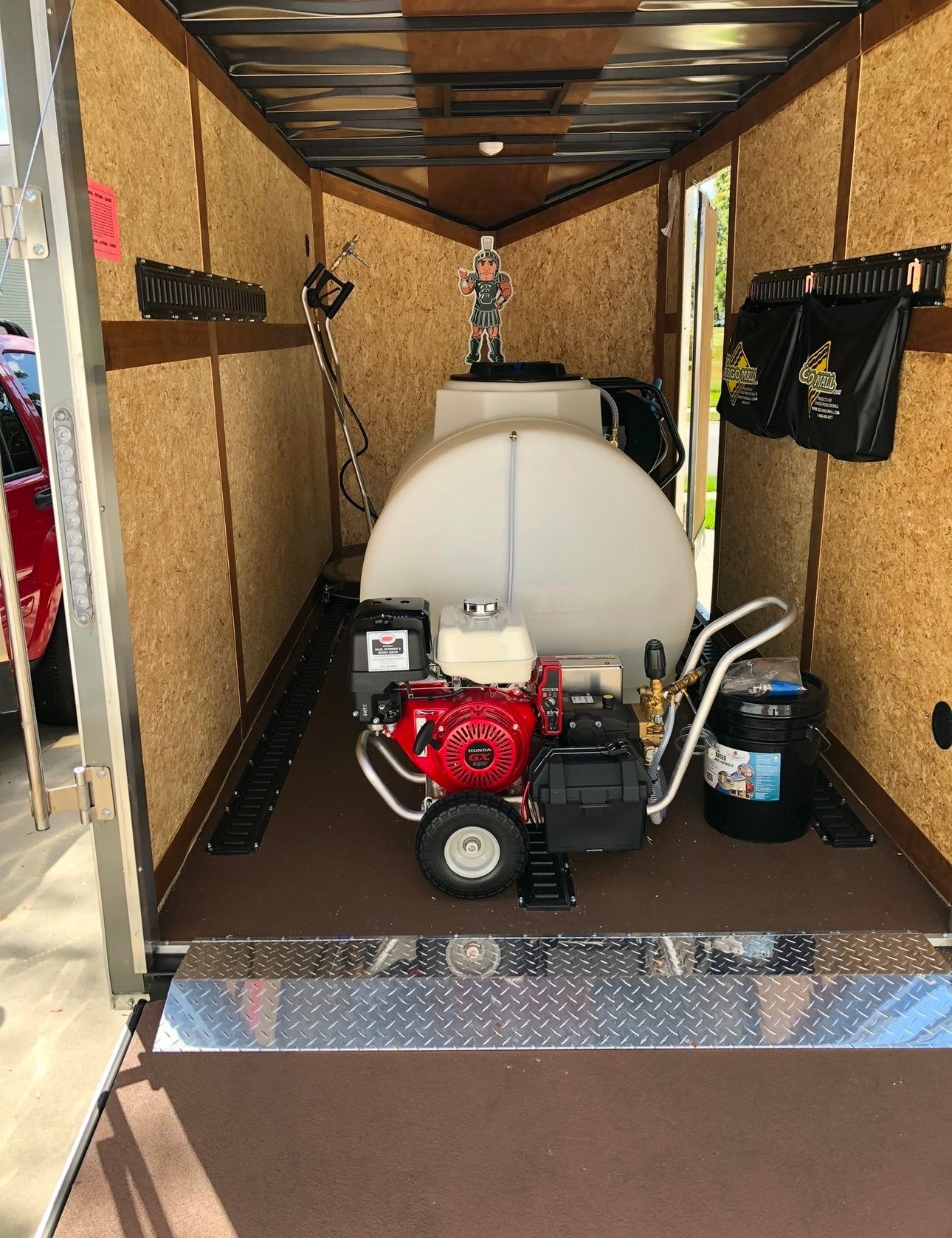 A pressure washer is sitting inside of a trailer
