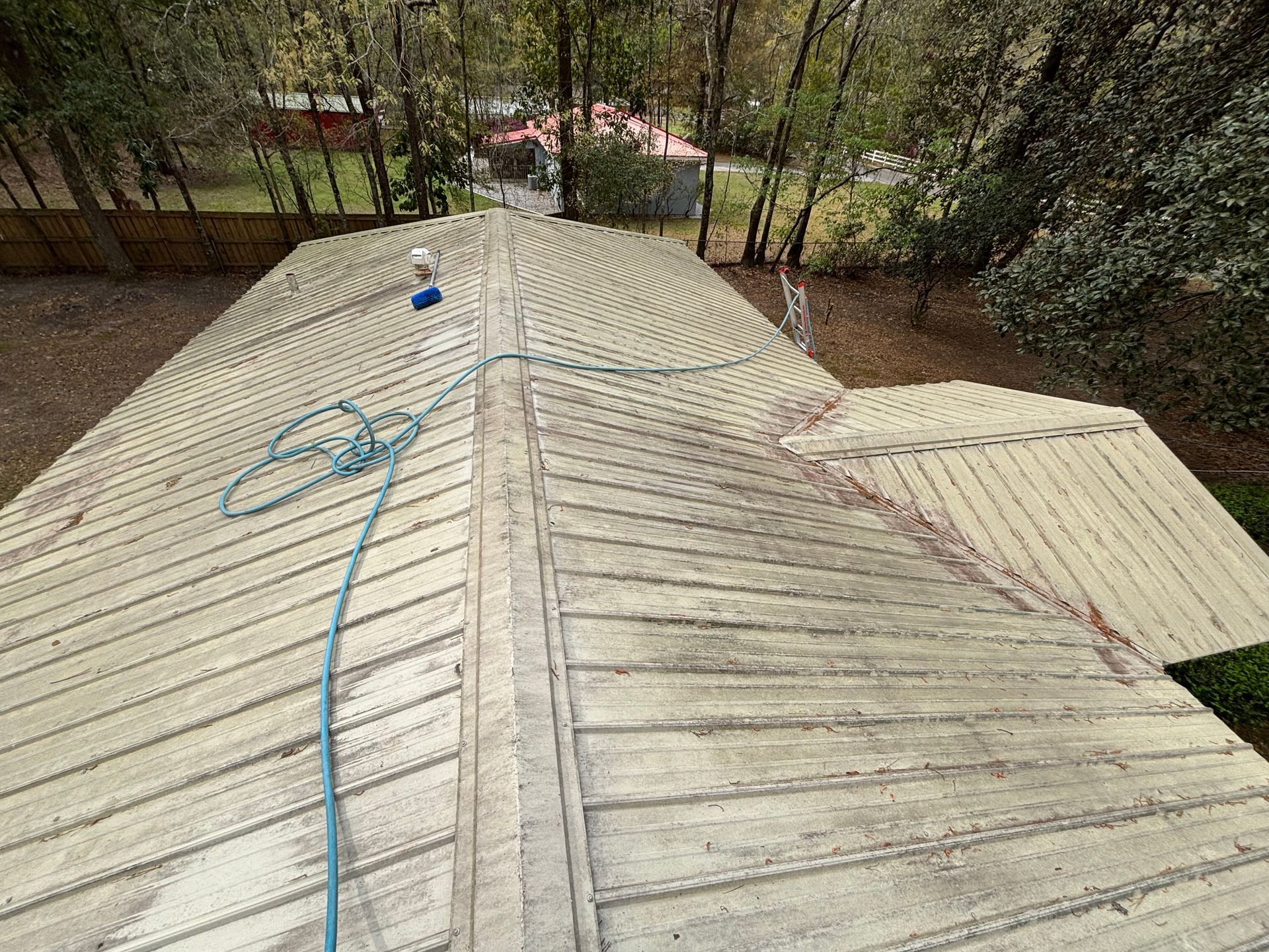 The roof of a house is being cleaned with a hose