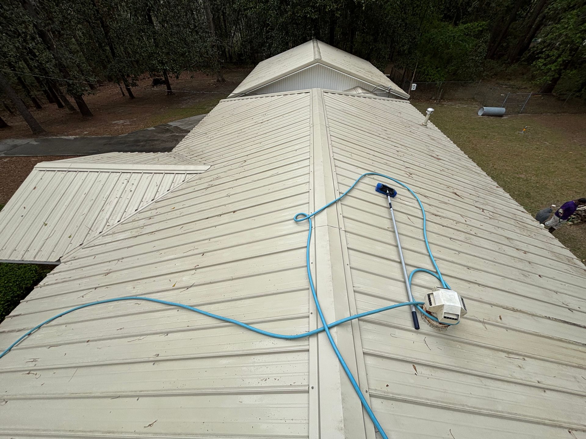 A white roof with a blue hose attached to it