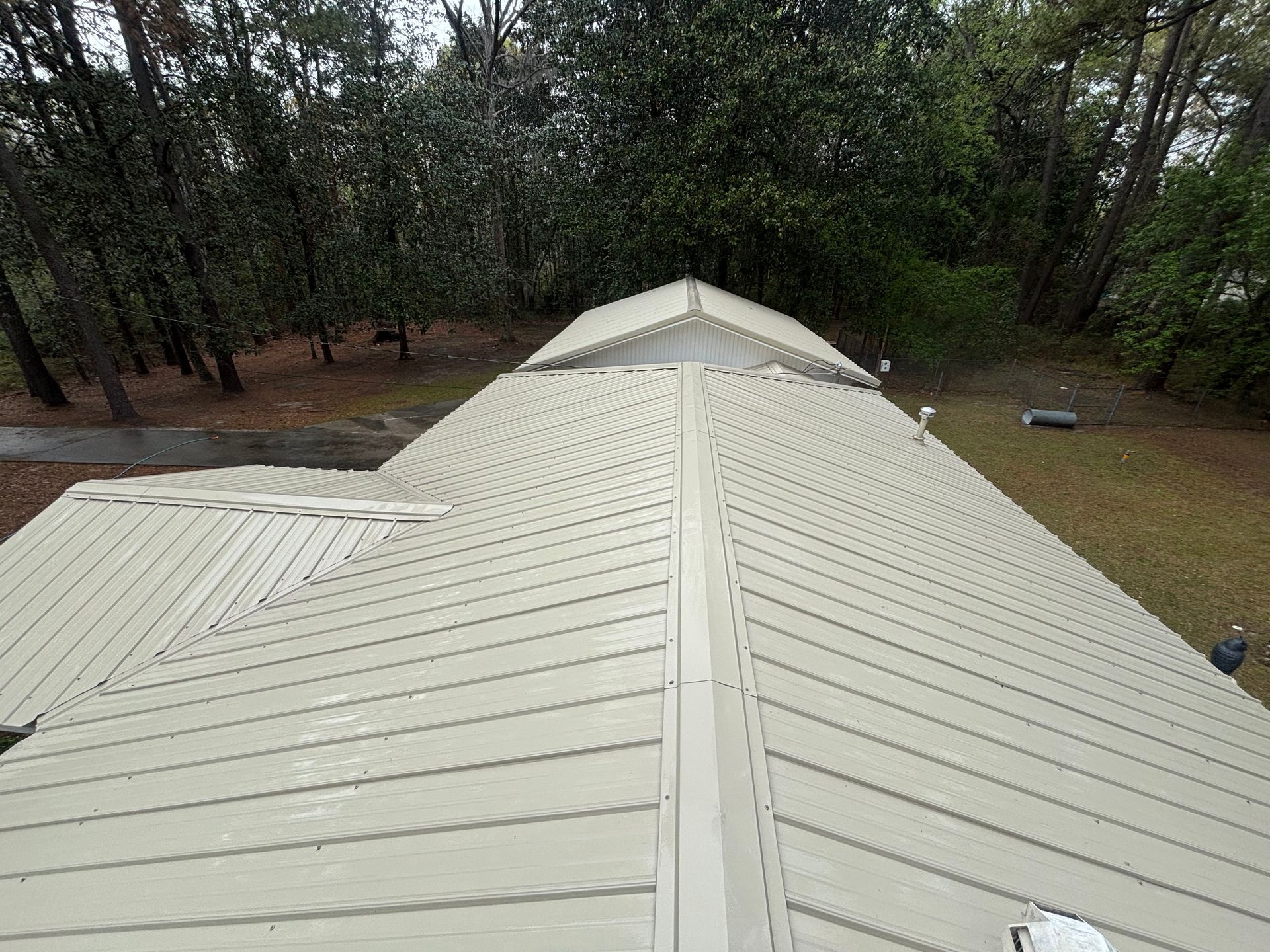 An aerial view of a roof with trees in the background