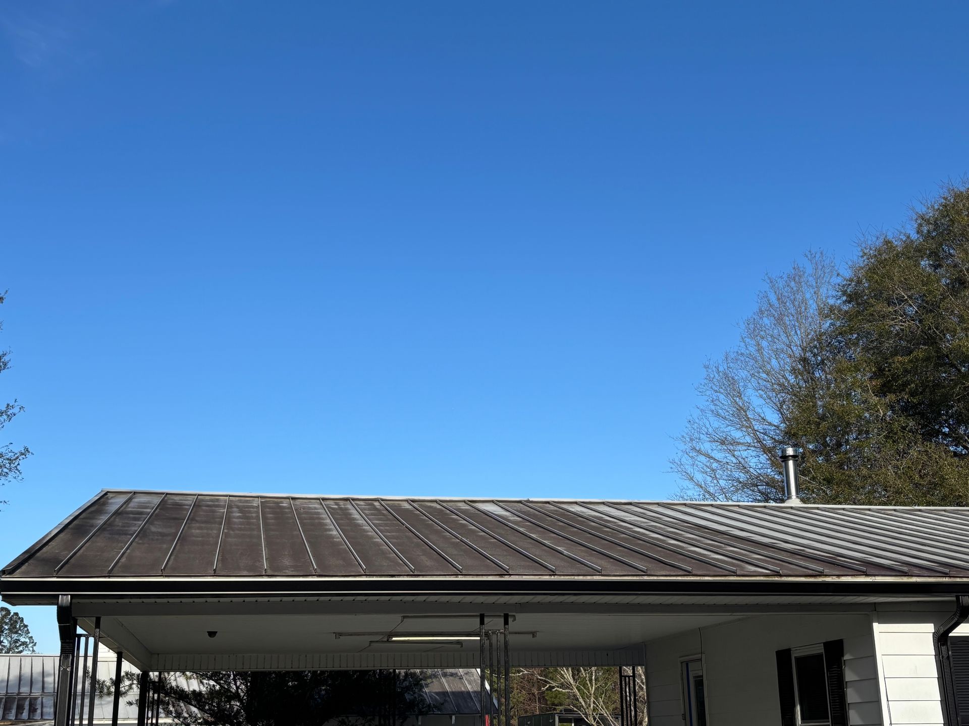 A house with a metal roof and a blue sky in the background