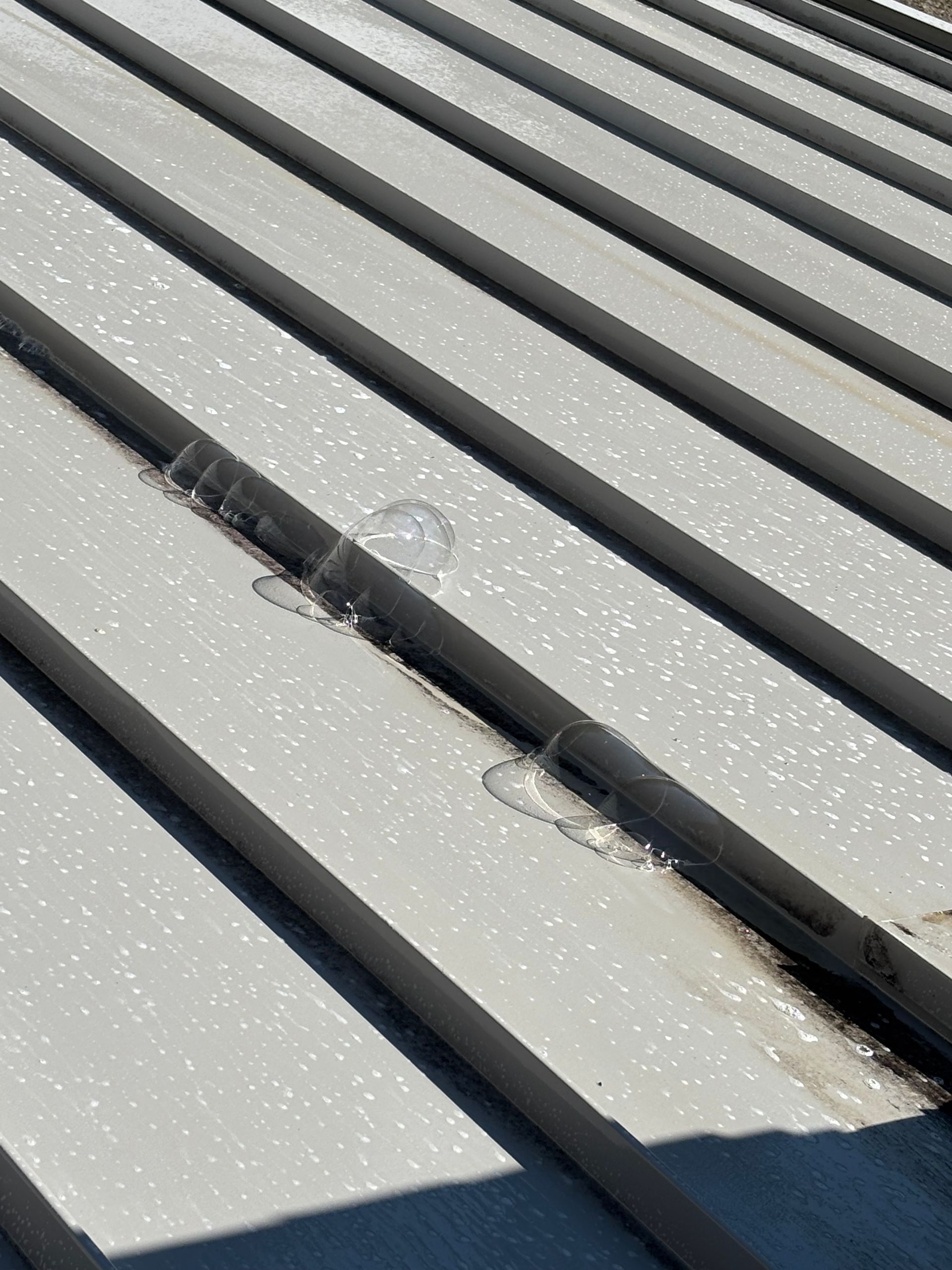A close-up of a metal roof with a hole in it