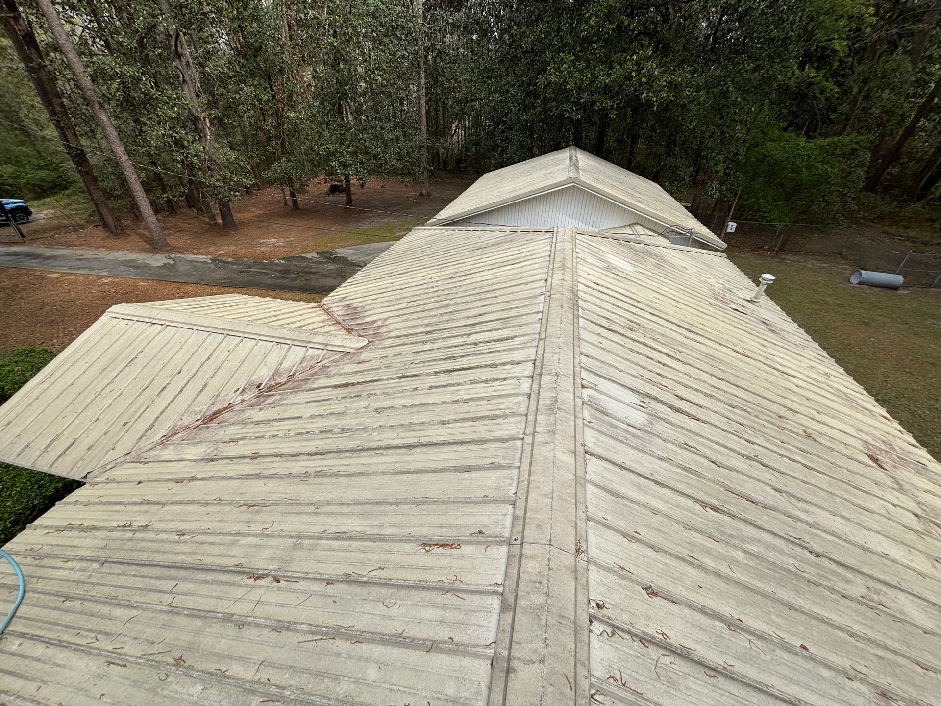 An aerial view of a roof with trees in the background