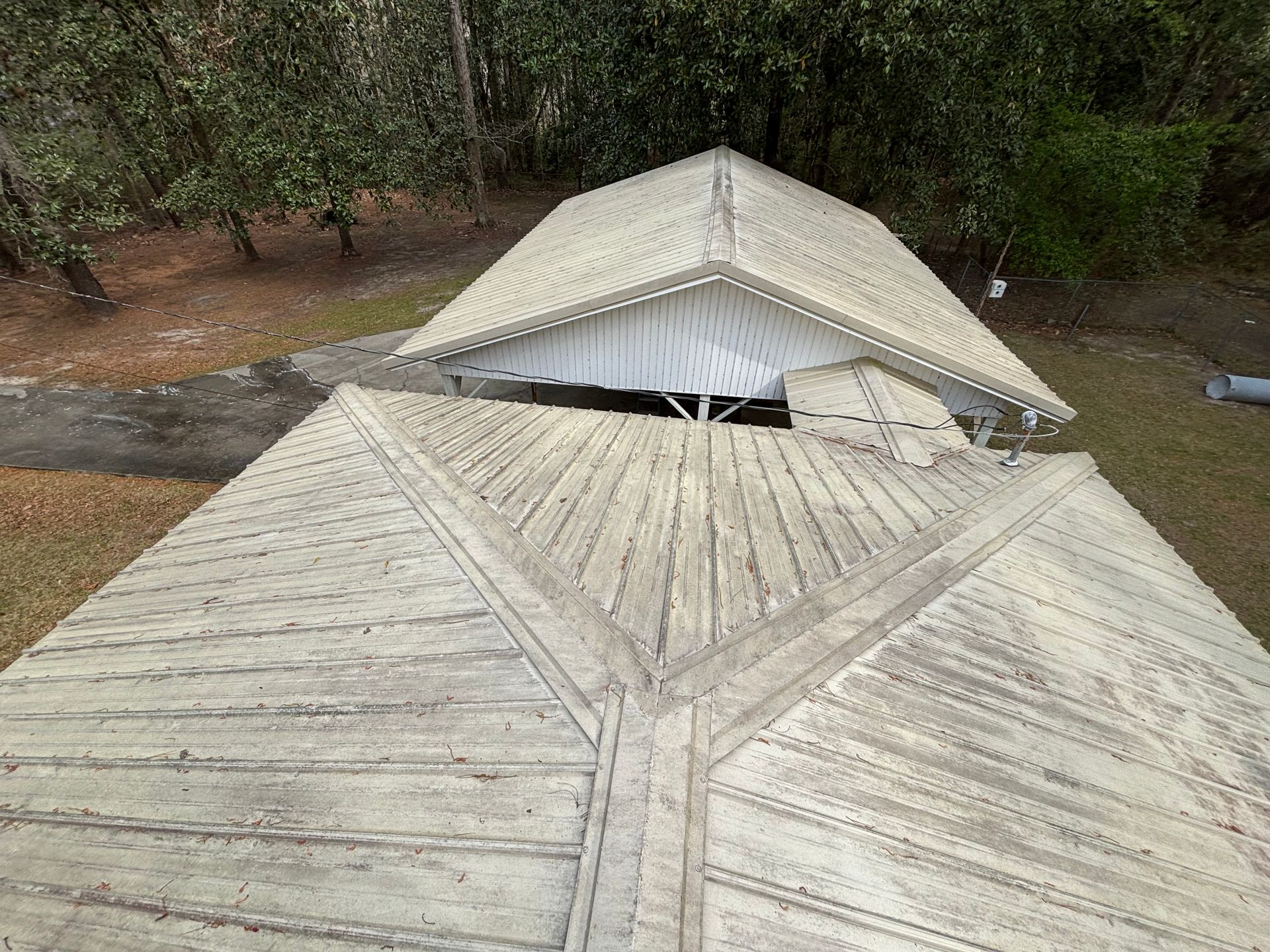 An aerial view of a wooden roof with trees in the background