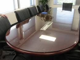 Oval conference table with black chairs in a bright office.