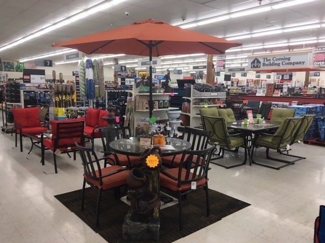 A store with tables and chairs and an orange umbrella