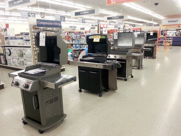 A bunch of grills are lined up in a store