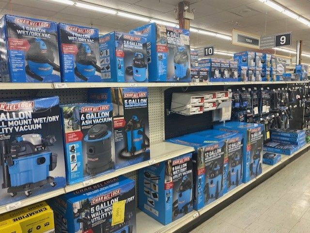 A store shelf filled with boxes of vacuum cleaners.