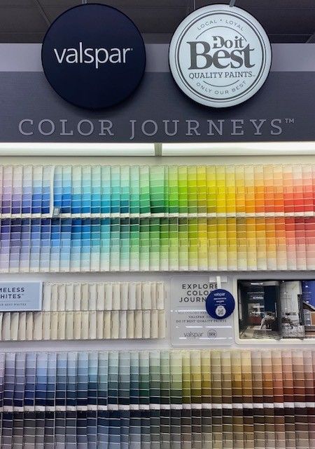 A wall filled with lots of different colored paints and a sign that says color journeys.