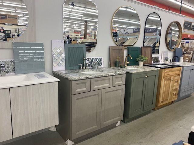 A row of bathroom vanities and mirrors in a store.