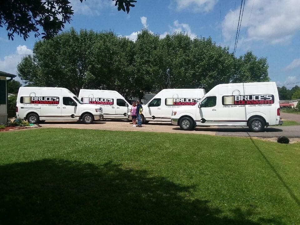 Four white vans parked on grass, with the company name 