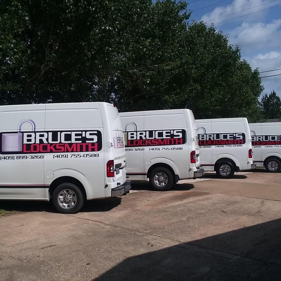 Four white vans parked outside with 