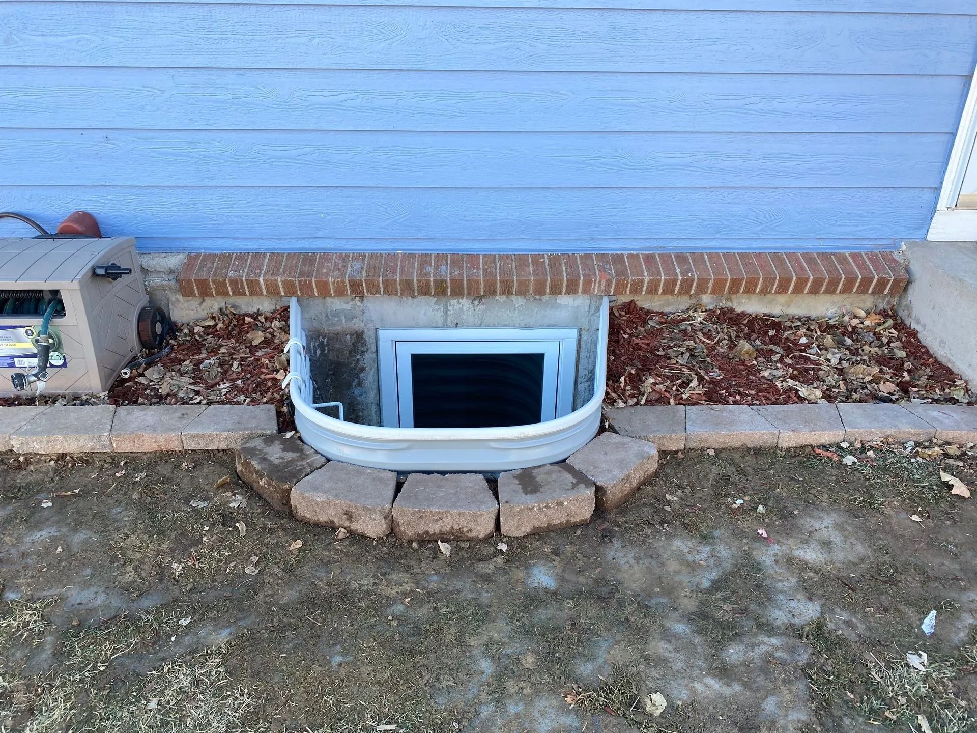 A window well in the side of a house.