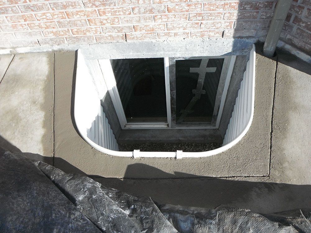 A window in a basement with a cross on it