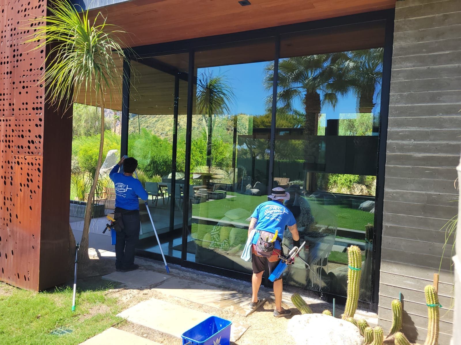 A group of people are cleaning the windows of a house.