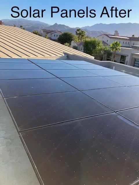 Solar panels installed on a rooftop, reflecting the sky and surrounding environment.