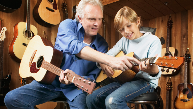 Instructor teaching guitar to a boy