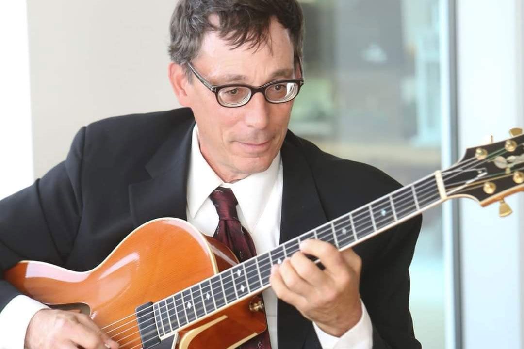 Richard Peare is playing a guitar