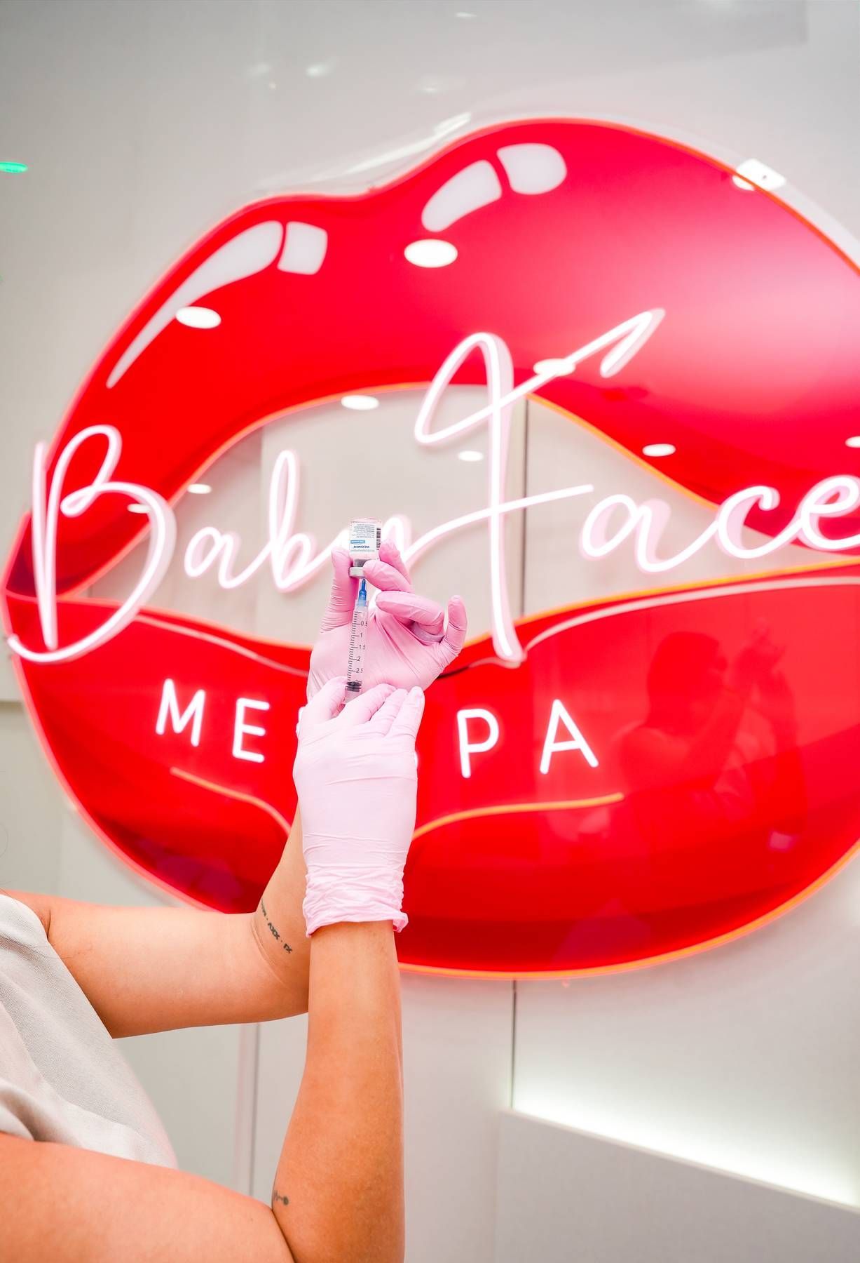 A woman is getting a botox injection in her cheek.